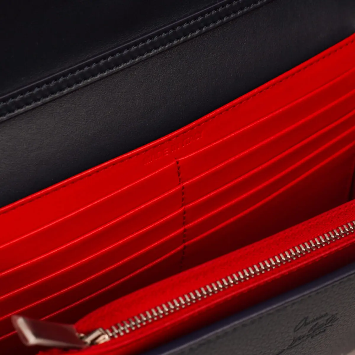 A close-up shot reveals the vibrant interior of a Christian Louboutin Paloma Clutch