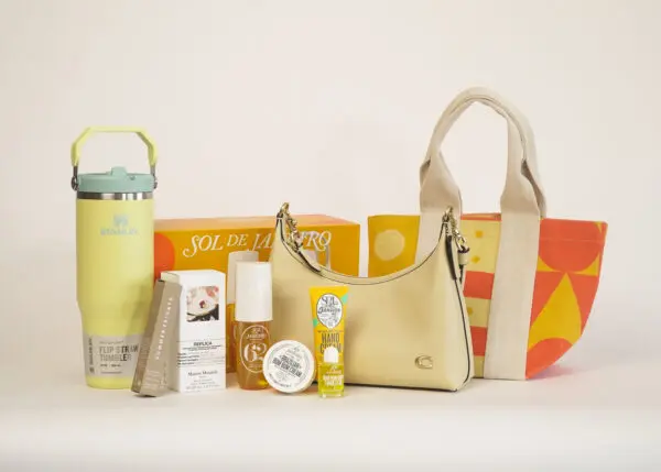 The image shows a collection of beauty and lifestyle products, including a water bottle, various skincare items, a handbag, and a tote bag, arranged on a white surface