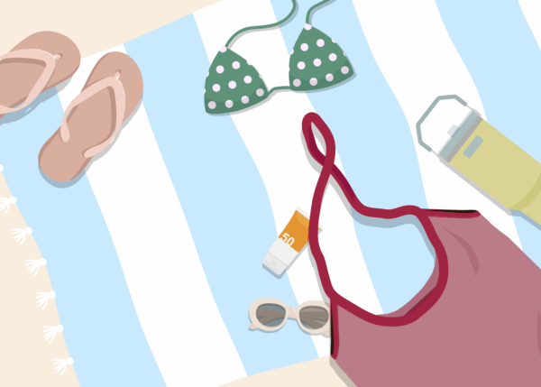 overhead flat lay shows beach essentials on a blue and white striped towel. From left to right are a pair of light pink flip-flops, a green polka-dot bikini top, a small tube of SPF 50 sun cream, white sunglasses, a large yellow sun cream bottle, and a reddish-pink swimsuit